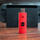 Illustration for article titled This Red Little Devil of a USB Stick Allows Any Controller on Nintendo Switch and Makes iPokémon Sword/i iand Shield /iTen Times Easier